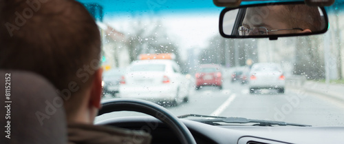 Fotografie driver eyes car driving steering wheel city road inside view