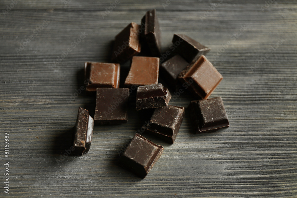 Pieces of chocolate on wooden background Pieces of chocolate on wooden background