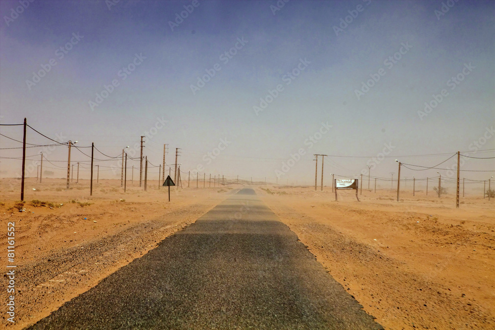 Fototapeta premium wind blowing across the desert sand road, Sahara, Morocco