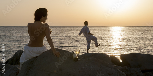 Silhouette of young couple on beach at sunrise