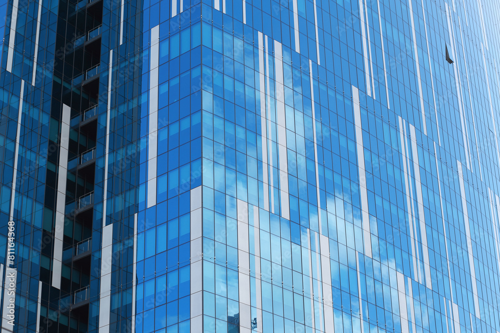 Glass facade of an urban building reflecting clouds Glass facade of an urban building reflecting clouds