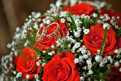 Rings bride and groom at the wedding bouquet of red roses