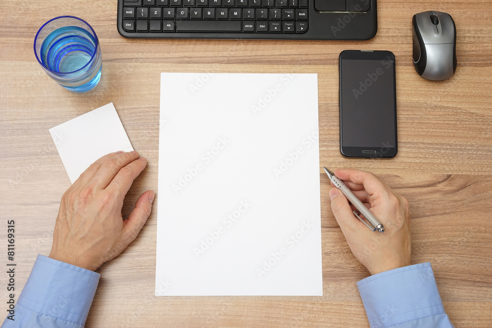 top view of desk with empty paper and man with pen in hand, read top view of desk with empty paper and man with pen in hand, read
