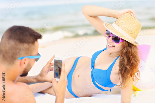 Couple taking pictures at the beach