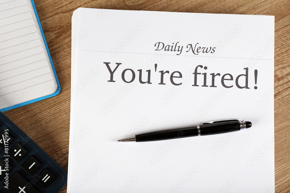 Message You're Fired on wooden table, top view