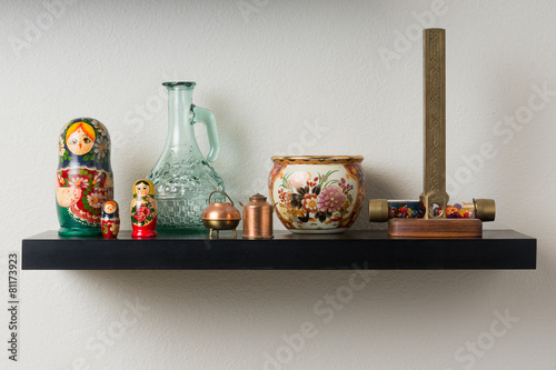 Wall shelf with pottery, kaleidoscope and dolls