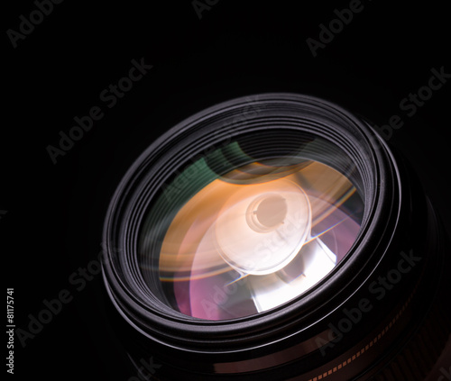 Photo lens closeup with colorful reflections. Black background