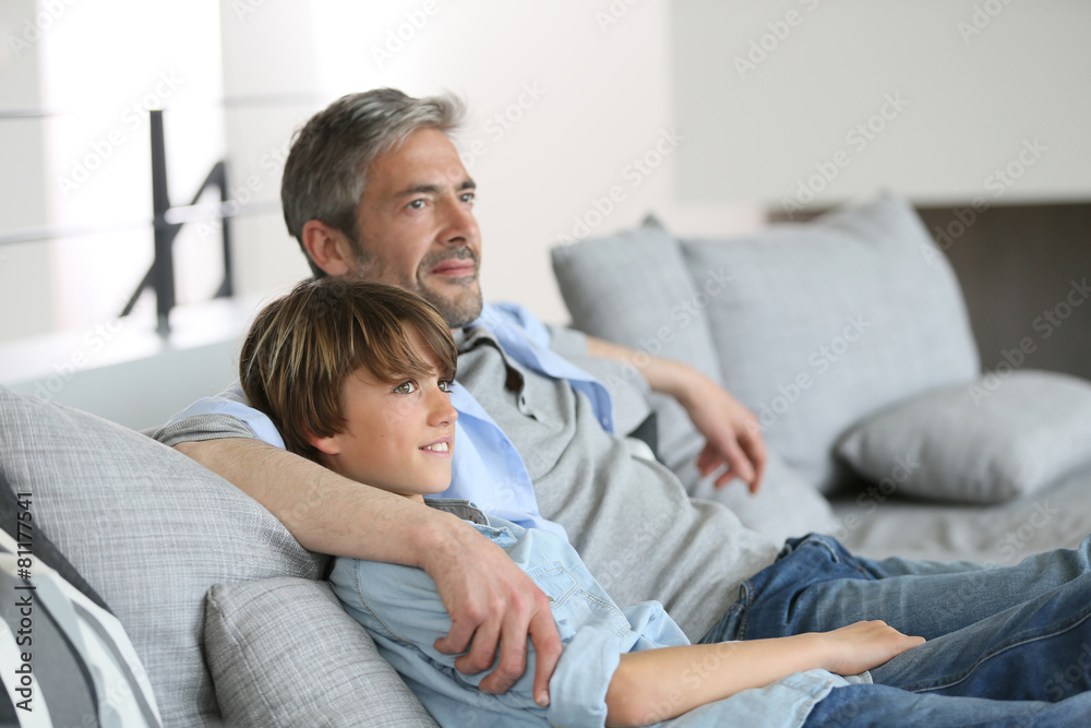 Father and son relaxing in sofa a thome
