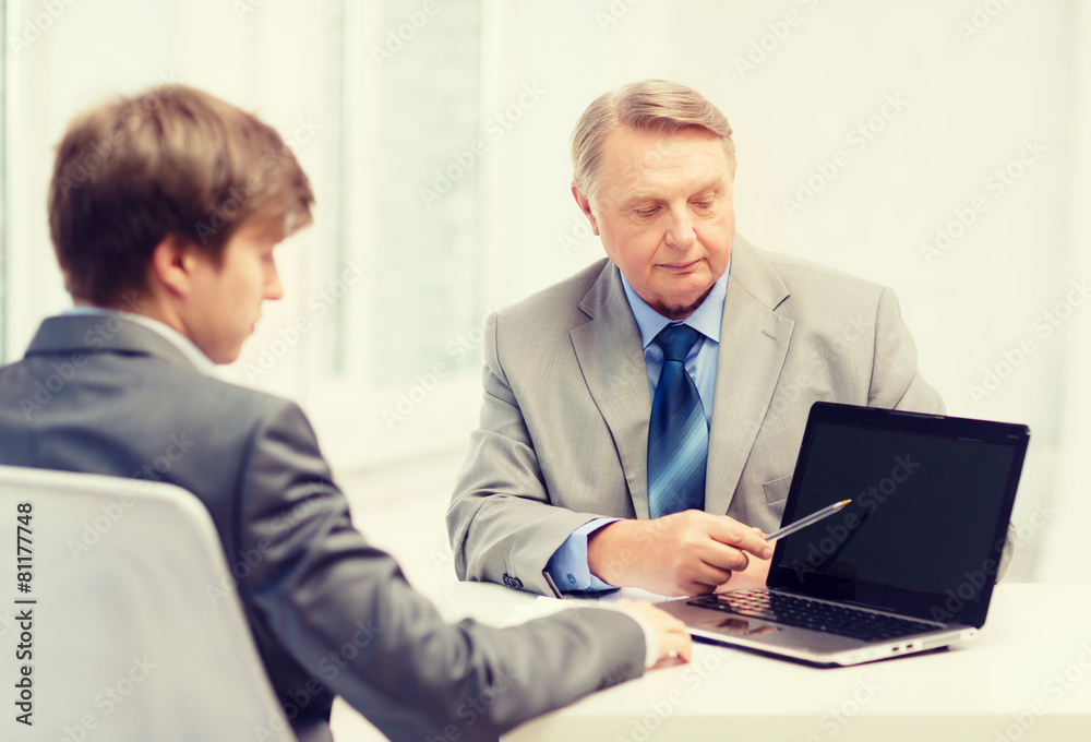older man and young man with laptop computer older man and young man with laptop computer