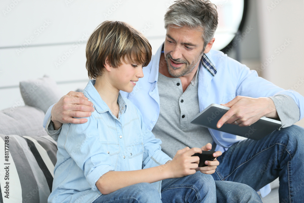 Obraz premium Father and son playing with smartphone