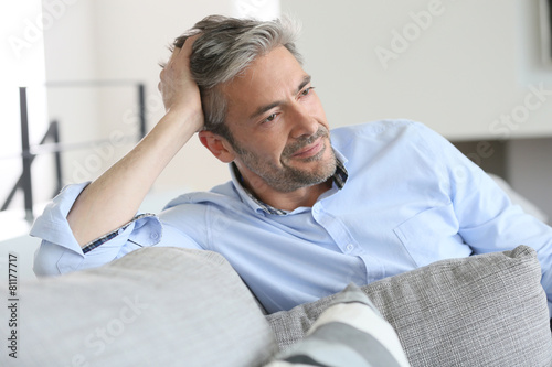 Smiling handsome 45-year-old man relaxing at home