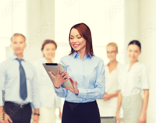 smiling woman looking at tablet pc at office