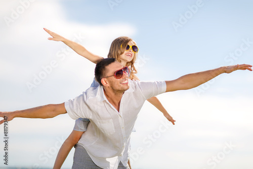happy father and child in sunglasses over blue sky