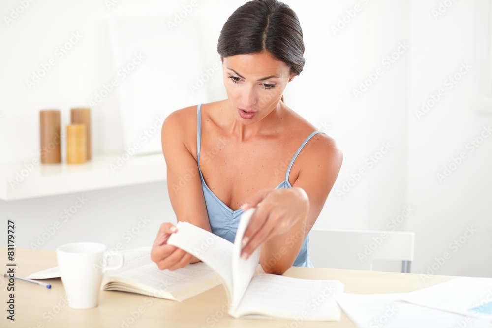 Surprised female sitting while studying her books Surprised female sitting while studying her books