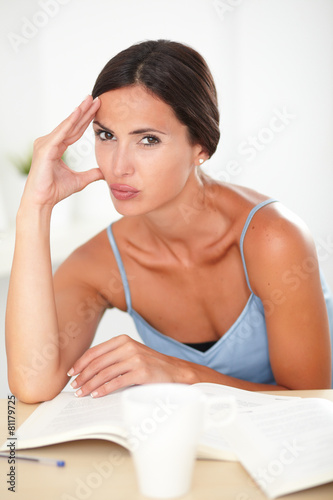 Beautiful female with headache studying books