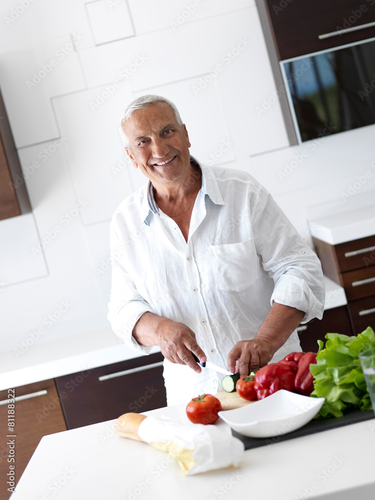 man cooking at home preparing salad in kitchen man cooking at home preparing salad in kitchen