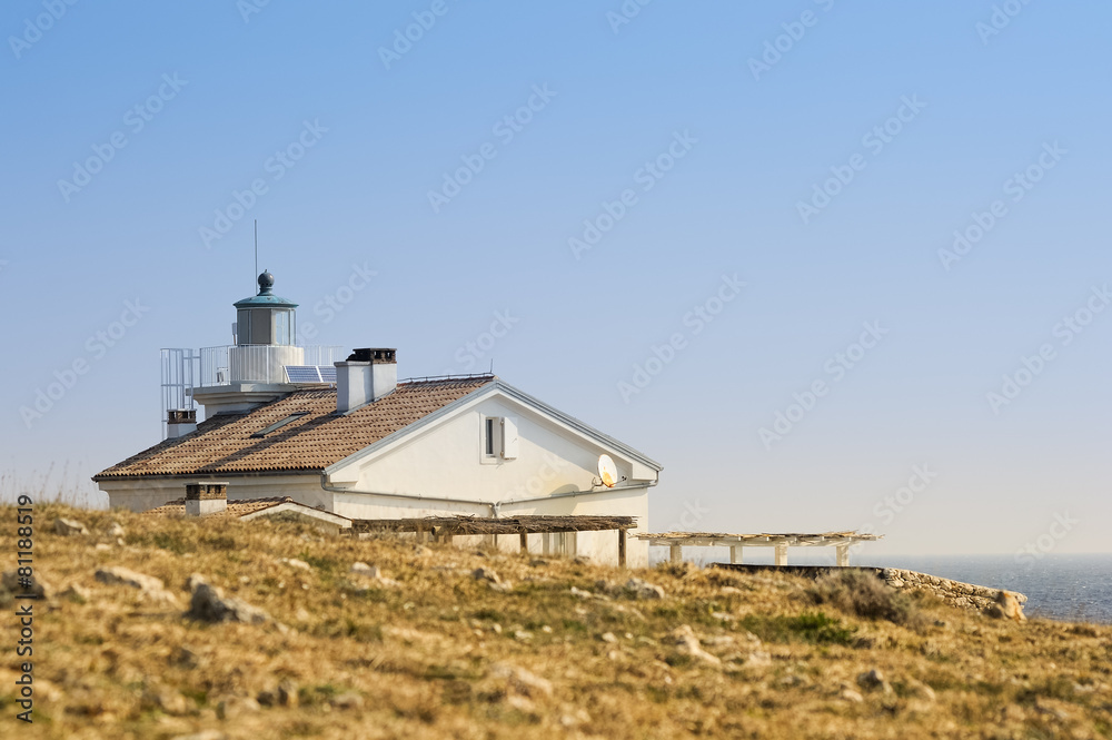 Leuchtturm mit Haus an der Küste