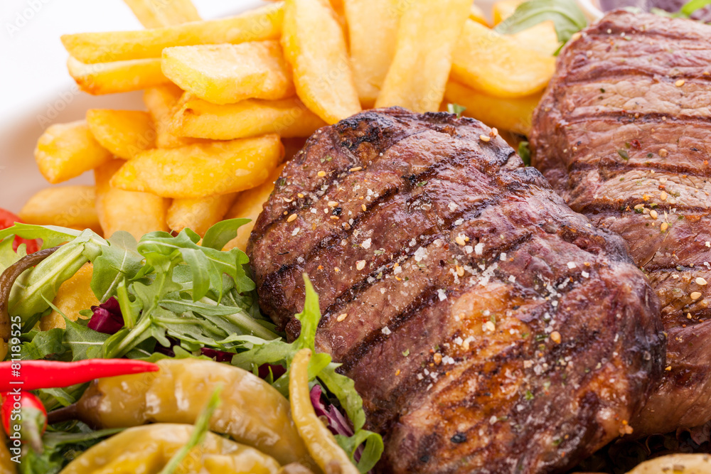 Platter of mixed meats, salad and French fries Platter of mixed meats, salad and French fries