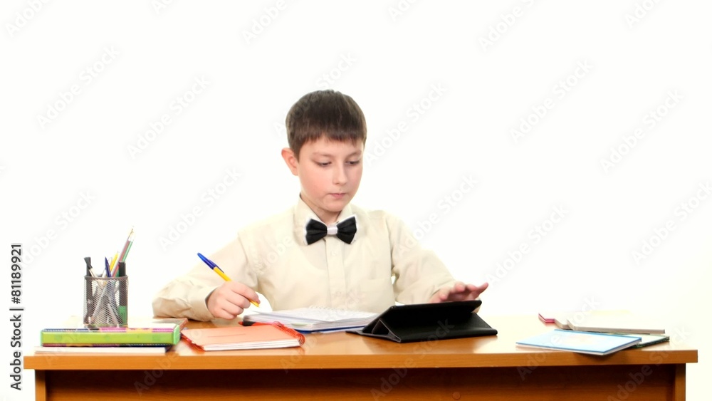 School boy taught lessons using the tablet computer doing School boy taught lessons using the tablet computer doing