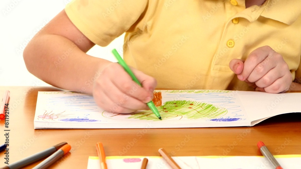 Little boy at the table drawing with felt-tip pen on white Little boy at the table drawing with felt-tip pen on white
