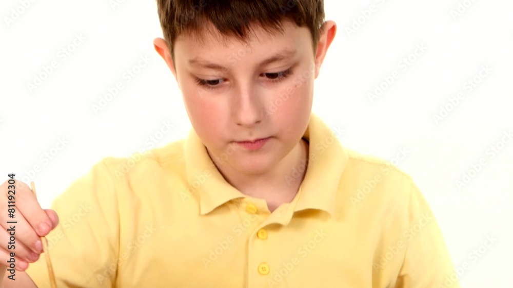 Little boy sitting at the table painting colors on white Little boy sitting at the table painting colors on white