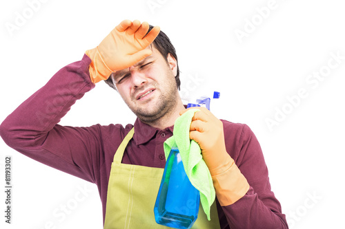 Young man with apron and gloves holding tired to clean