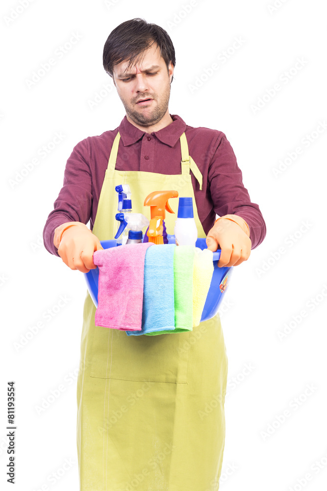 Unhappy young man with apron and cleaning equipment Unhappy young man with apron and cleaning equipment