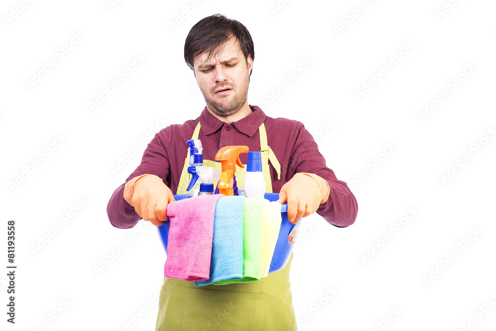 Unhappy young man with apron and cleaning equipment Unhappy young man with apron and cleaning equipment