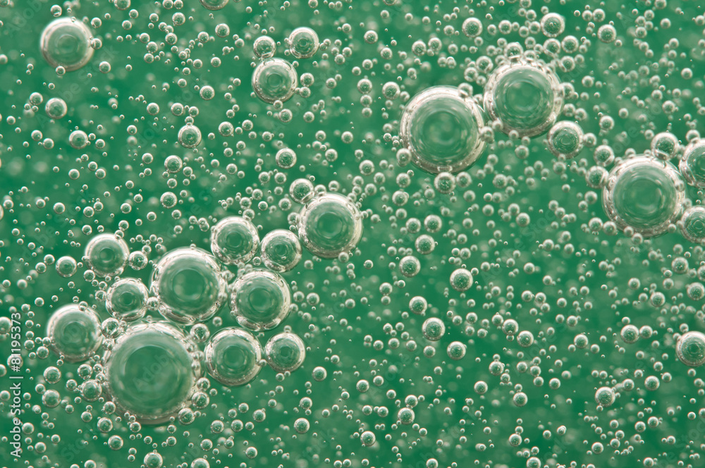 Macro Oxygen bubbles in water on a green background