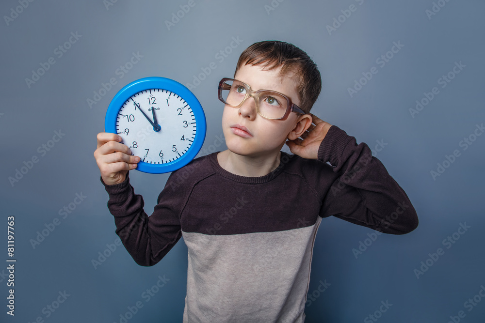 European-looking boy of ten  years  holding a wall  clock reflec