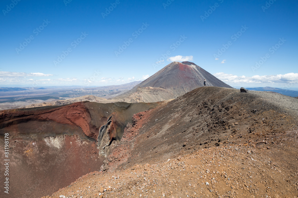 Hiker next to red crater