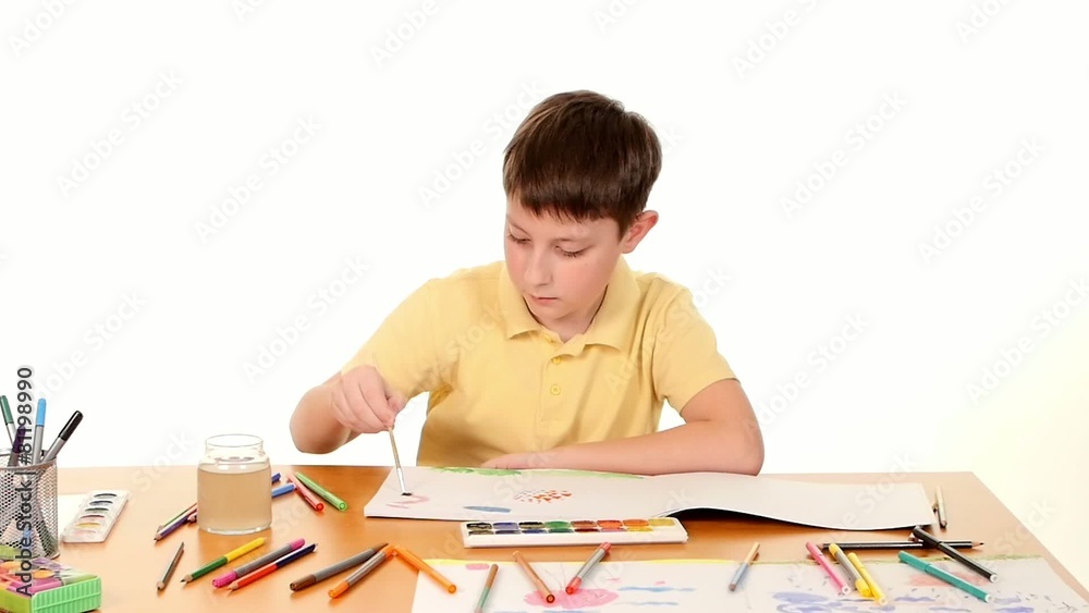 Little boy at the table drawing with felt-tip pen on white Little boy at the table drawing with felt-tip pen on white