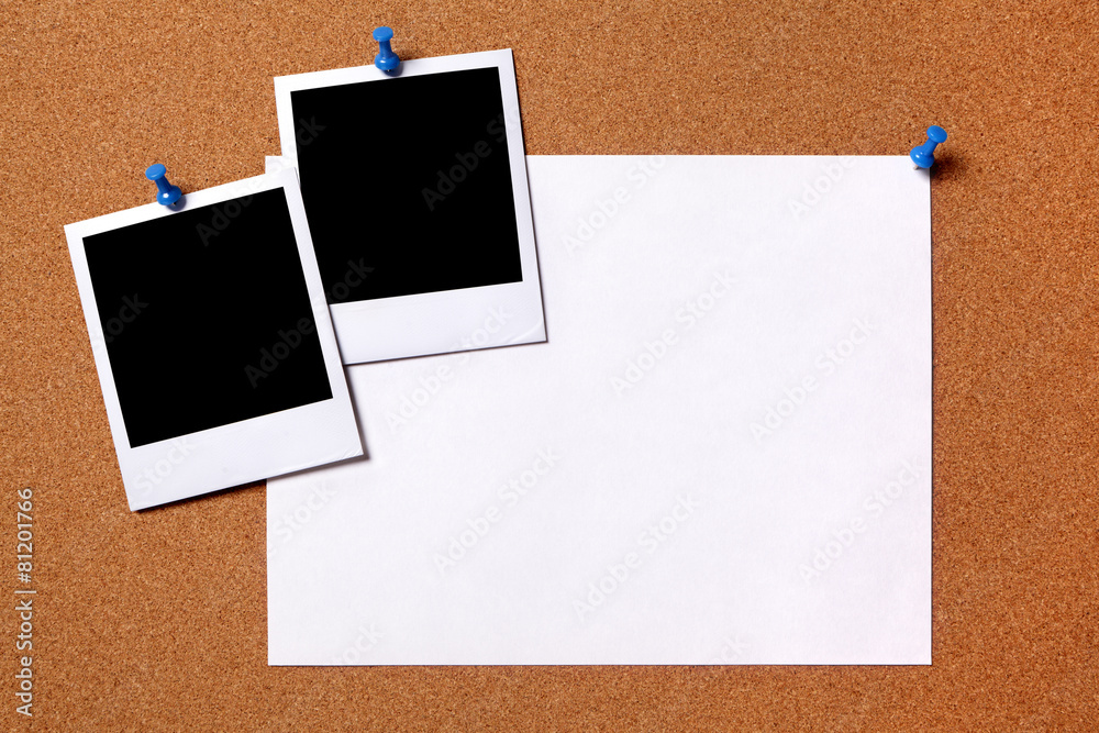 Two polaroid style photo frame print pinned to a cork notice board background with blank paper poster for text or advertising Two polaroid style photo frame print pinned to a cork notice board background with blank paper poster for text or advertising