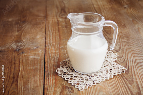 milk in jug on wooden surface