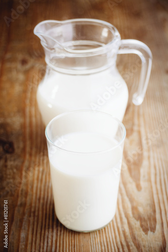 milk in jar and glass on wooden surface