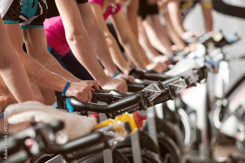 gym detail shot - people cycling, spinning class photo