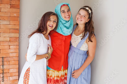 three friends of different religions standing happily together photo