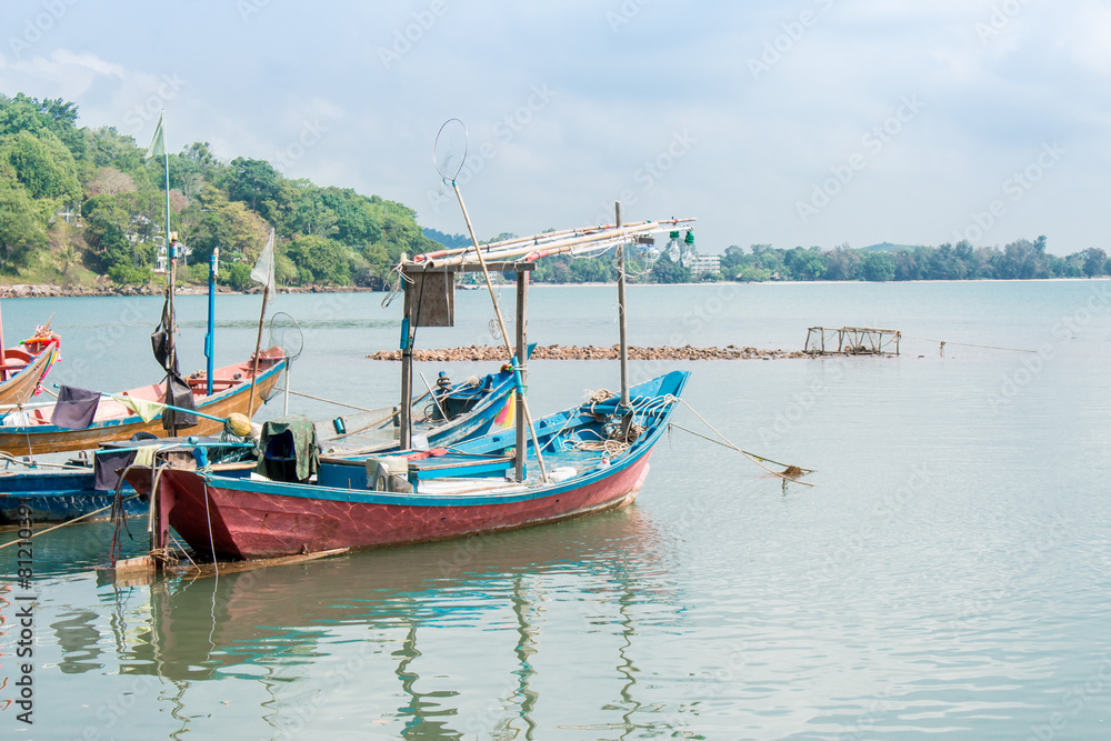 A fishing boat is moored at a fishing village, in the sea.