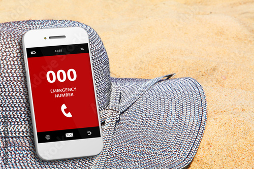 mobile phone with emergency number 000 on the beach