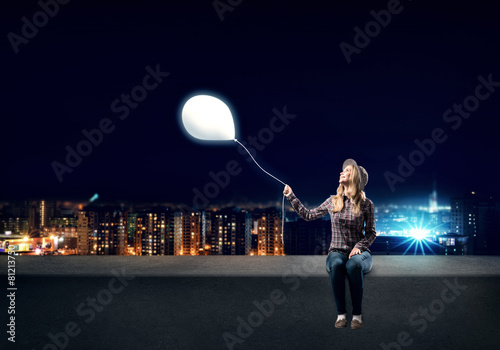 Young woman in casual holding balloon