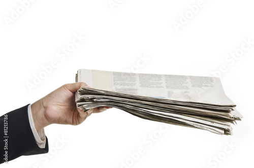 a female hand holding newspapers