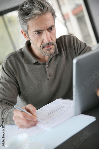 Mature businessman working from home with tablet