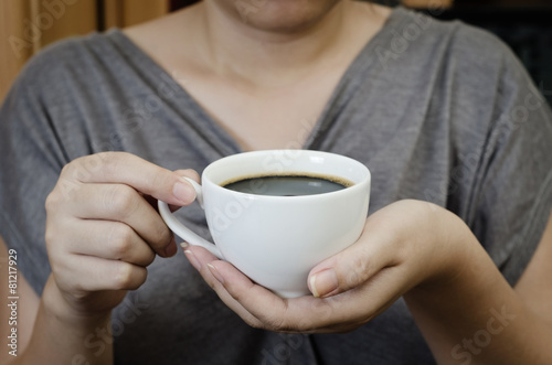 a young woman holding a cup of cafe