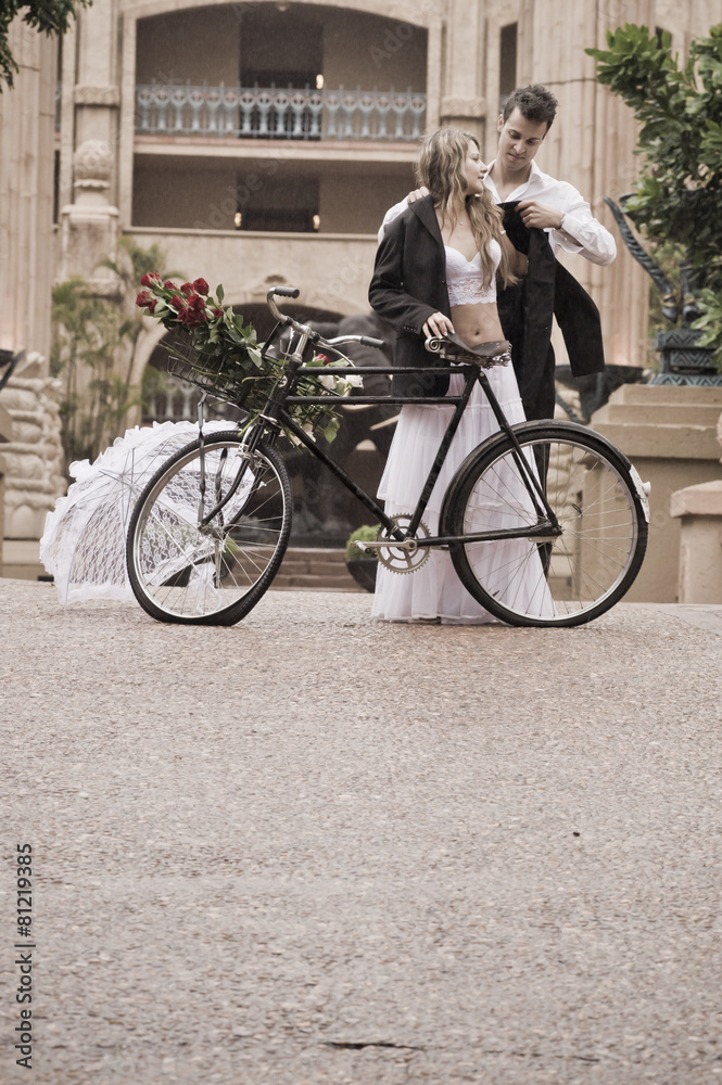 Young attractive couple walking outdoors with vintage bicycle