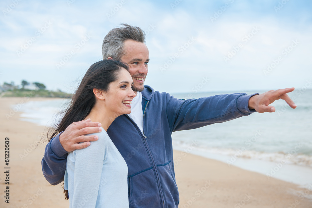 A beautiful couple is posing holding eachother at the beach A beautiful couple is posing holding eachother at the beach