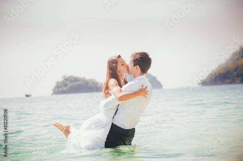 groom embrace his bride standing half in sea water © SlavaStock