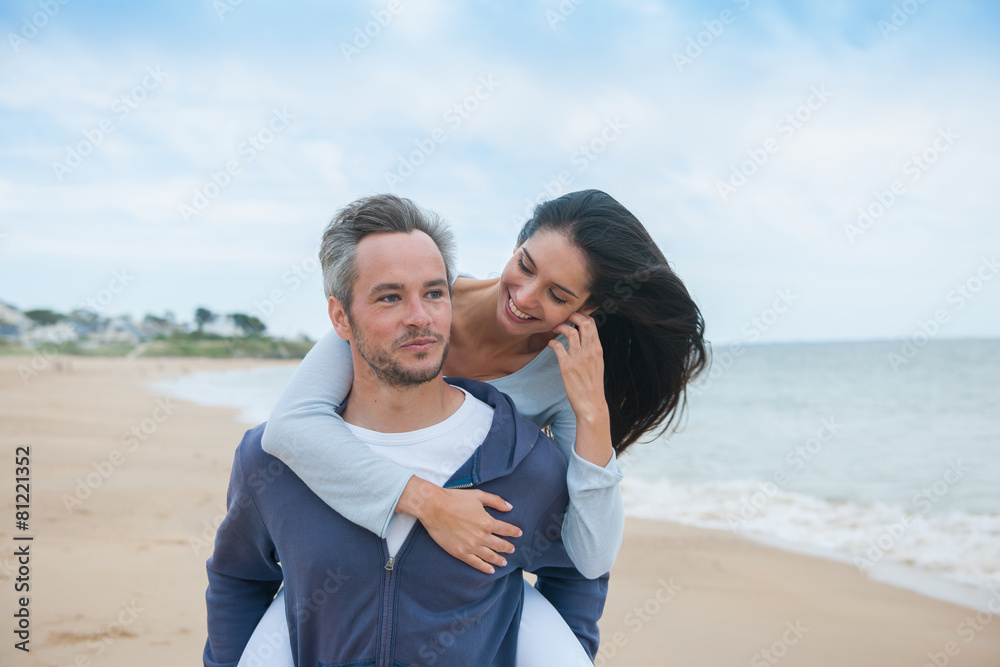 A beautiful couple is posing holding eachother at the beach A beautiful couple is posing holding eachother at the beach