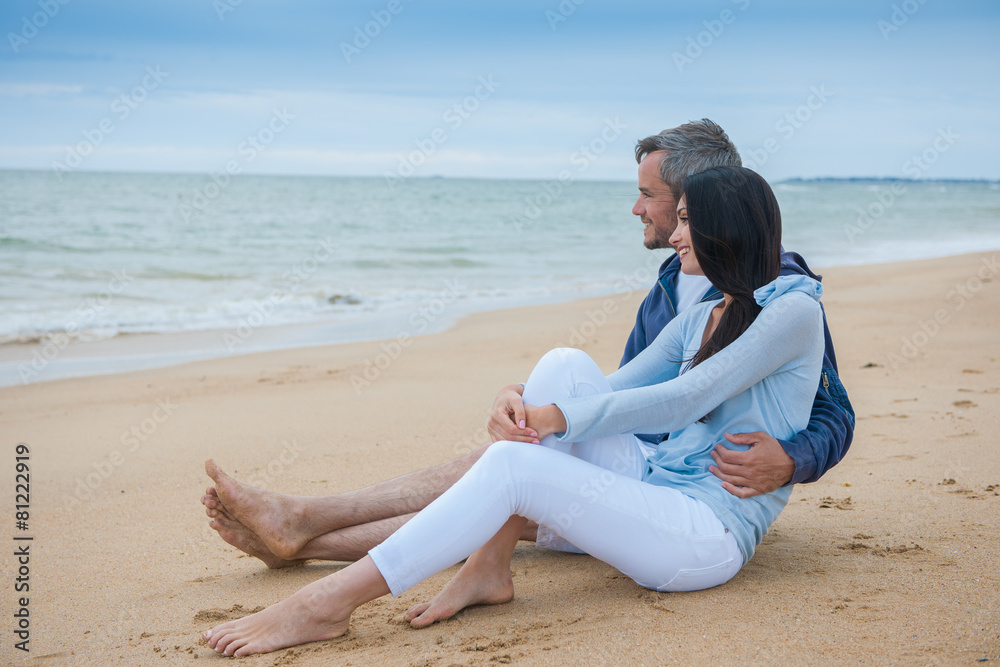 A beautiful couple is holding eachother at the beach