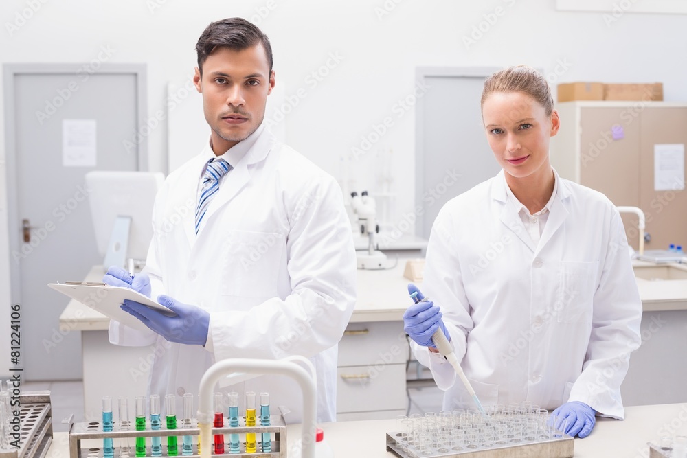 Scientists examining tubes Scientists examining tubes