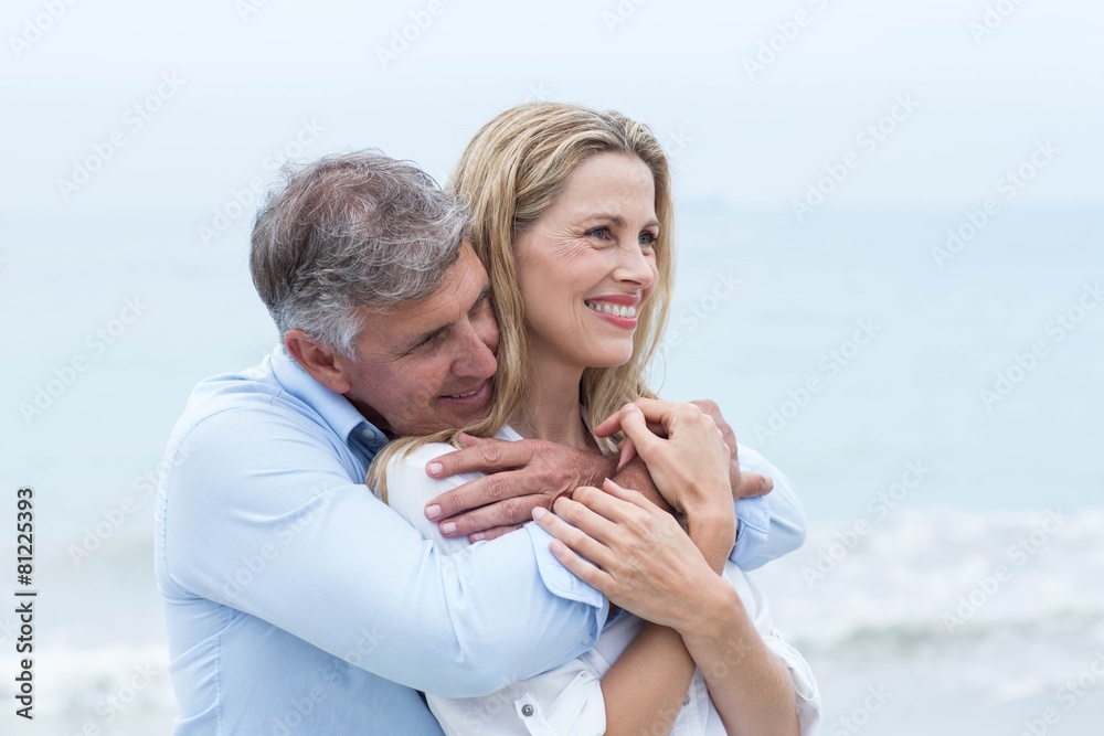 Fototapeta premium Happy couple hugging each other by the sea